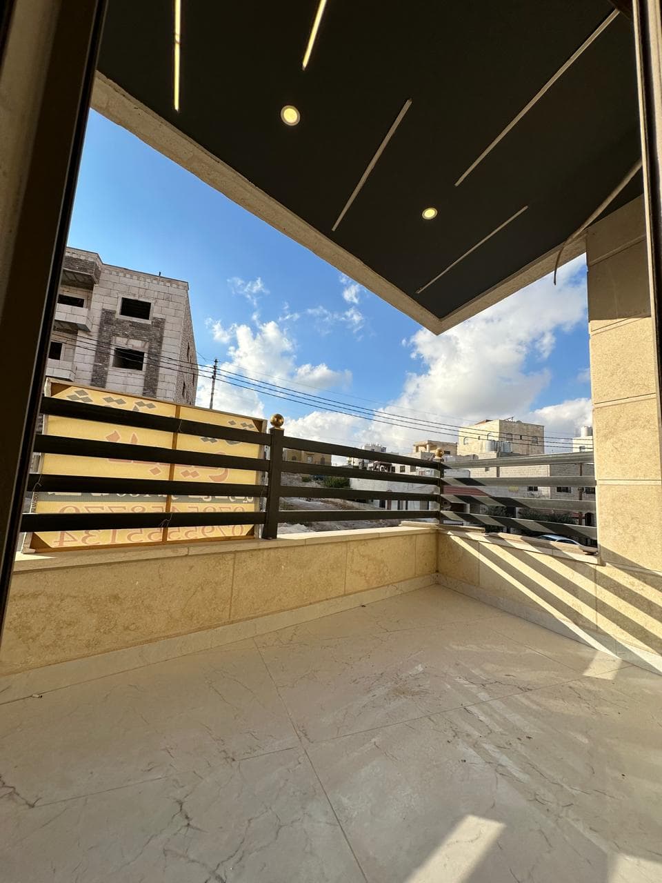 فرندة بدرابزين معدني وإطلالة على الحي