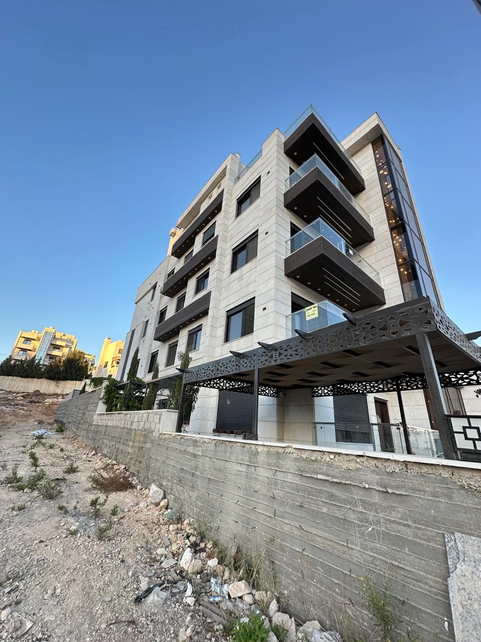 مشروع الحويطي ١ — عمارة سكنية حديثة بواجهة حجرية وشرفات داكنة في الحويطي