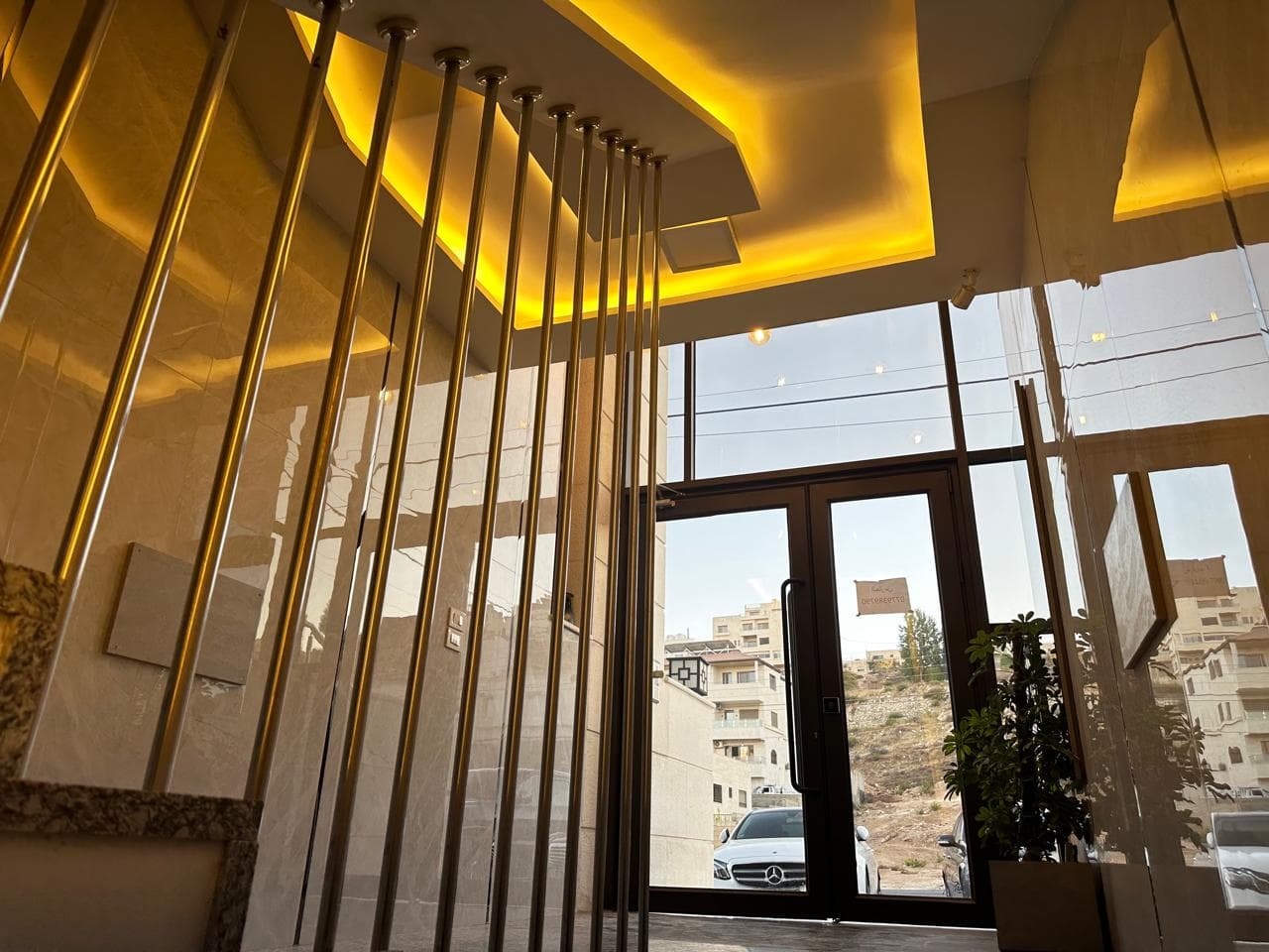 بيت الدرج بقضبان ذهبية وإنارة مخفية دافئة